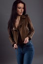 Glamorous portrait of a pretty brunette in jeans and an open jacket on her naked sexy body Royalty Free Stock Photo