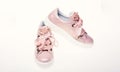 Glamorous sneakers concept. Footwear for girls and women decorated with pearl beads. Pair of pale pink female sneakers