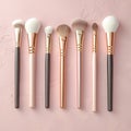 Glamorous white and gold makeup brushes on pink background