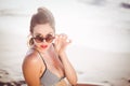 Glamorous woman looking over sunglasses on the beach Royalty Free Stock Photo