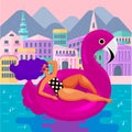 Glamorous woman resting in a huge trendy swimming circle in the form of a pink Flamingo on the background of hotels and villas