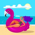 Glamorous woman resting in a huge trendy swimming circle in the form of a pink Flamingo on the beach