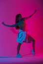 Glamorous young woman dancer in trendy sports youth clothes posing in a room with multi-colored pink color disco style. Attractive