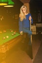 Glamour beauty woman plays billiard on pool table Royalty Free Stock Photo