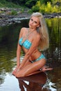 Glamour blond model with body in blue bikini posing pretty at the nature location Royalty Free Stock Photo