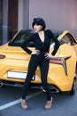 Glamour brunette babe standing near luxury sport car Royalty Free Stock Photo