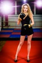 Glamour fashion model woman with boxing gloves in sports gym.