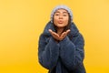 Glamour and fashion. Portrait of lovely carefree girl in warm winter hat and fur coat, stylish urban outfit, sending air kiss Royalty Free Stock Photo