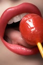 Glamour macro shoot with woman's lips with a sweet bonbon lollipop Royalty Free Stock Photo