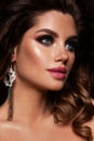 Glamour portrait of beautiful girl model with makeup and romantic hairstyle. Fashion shiny highlighter on skin, gloss