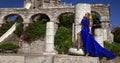 Glamour, stylish elegant woman in blue long evening gown dress is posing near the pool in luxury resort outdoor Royalty Free Stock Photo