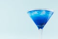 Glamour tropical fruit blue cocktail with curacao, ice cubes in misted martini glass in modern mint color background, top part. Royalty Free Stock Photo