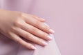 Glamour woman hand with light pink nail polish on her fingernails. Pink nail manicure with gel polish at luxury beauty salon. Nail Royalty Free Stock Photo