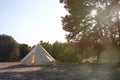 Glamping campsite in the forest at sunset. Big camping tent for luxury outdoor vacation. Staycations, hyper-local travel, night