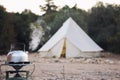 Glamping lifestyle. Boiling kettle with steam near big retro camping tent. Luxury travel accomodation into the forest Royalty Free Stock Photo