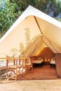 Glamping open tent with cozy interior on a sunny day. Glamorous camping tent for outdoor summer holiday and vacation lifestyle