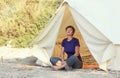 Glamping outdoor vacation. Woman relax near big camping tent with cozy interior. Luxury travel accomodation into the forest Royalty Free Stock Photo
