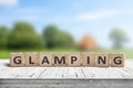 Glamping sign on wooden planks in the summer Royalty Free Stock Photo