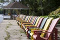 Zoom in view of the multi-coloured Muskoka Chairs in the waterfront of the tourist resort