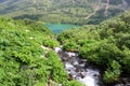 A glance at a high-mountain river flowing along the slope to a wide lake Royalty Free Stock Photo