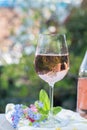 Glas of cold rose wine, outdoor terrase, sunny day, spring garden flowers