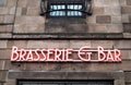 Exterior shot of Brasserie and Bar neon sign on an old stone wall Royalty Free Stock Photo