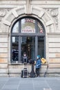 Two young buskers wait with equipment to set up outside a TGI Friday restaurant