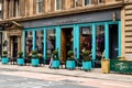 Exterior landscape view of Glasgow Topolabamba Restaurant, with entrance doorway and windows with street signs and tables
