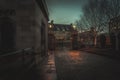 GLASGOW, SCOTLAND, DECEMBER 16, 2018: Creepy cobbled street surrounded by old European style buildings. Illuminated only with weak Royalty Free Stock Photo