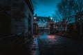 GLASGOW, SCOTLAND, DECEMBER 16, 2018: Spooky cobbled street surrounded by old European style buildings. Illuminated only with weak Royalty Free Stock Photo