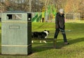 Single lady walking her dog alone in public park