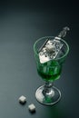 A glass of absinthe and a stainless steel slotted spoon