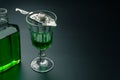 A glass of absinthe and a stainless steel slotted spoon