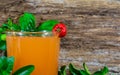 Glass of acerola juice (Malpighia emarginata) on aged wooden background