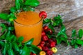 Glass of acerola juice (Malpighia emarginata) on aged wooden background