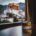 Glass of alcohol with ice on a table with a view of a castle