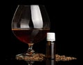Glass with alcohol, liquid for Smoking and scattered tobacco isolated on black