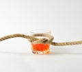 Glass with alcohol tied in a knot of rope, alcoholism treatment concept, drunkenness in the family