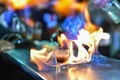 Glass with an alcoholic drink on fire at a bar counter. Fiery show at the bar. The bartender makes hot alcoholic cocktail and