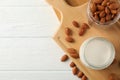 Glass of almond milk, almond seeds on white table again blue background, space for text Royalty Free Stock Photo