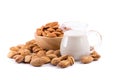 Glass of Almond milk with a heap of almonds on white background