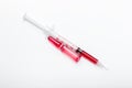 Glass ampoule with red virus vaccine with syringe.