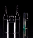 Glass ampoules close up. Medical ampoules. Medical ampoules, syringe needle on a black background