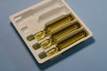 Glass ampoules with medicine on a gray background.