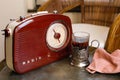 A glass in an antique cup holder with tea and a retro radio are on a copper table Royalty Free Stock Photo