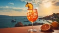 Glass of Aperol Spritz cocktail takes center stage on a table in a charming seaside restaurant. The warm hues of the setting in