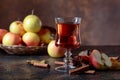 Glass of apple juice or cider with juicy apples and cinnamon sticks. Royalty Free Stock Photo