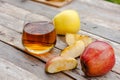 Glass of apple juice with fresh red apple on wooden table. Apple cut into slices. Harvest autumn vitamin concept.