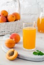 Glass with apricot juice and apricot fruits in basket Royalty Free Stock Photo