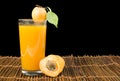 Glass apricot juice and fruits black .